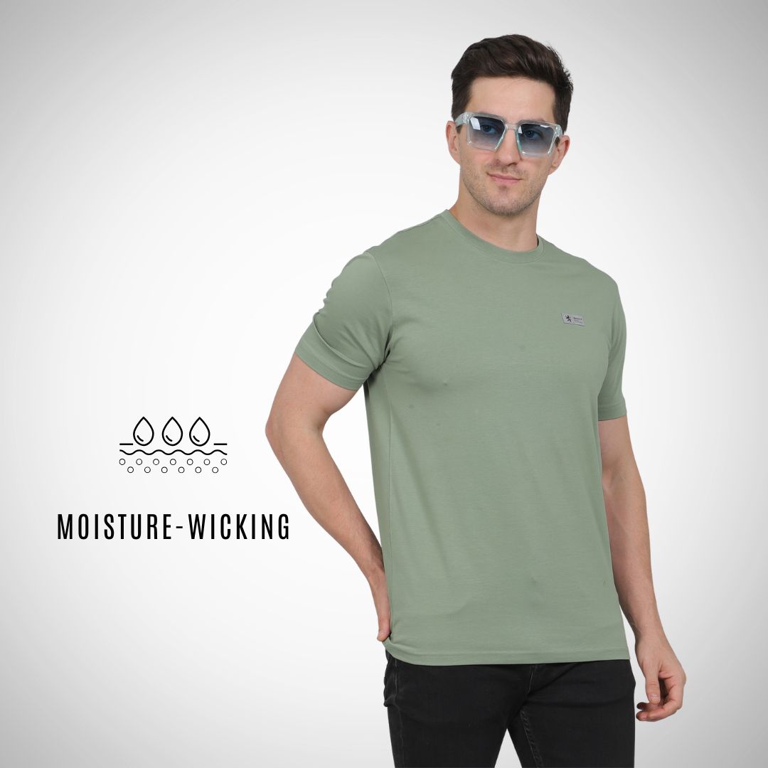Man wearing a green t-shirt with moisture-wicking text on a white background