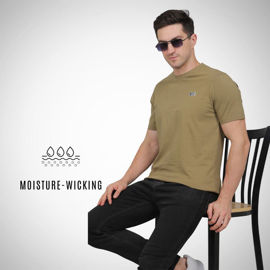Man wearing a green t-shirt sitting on a chair with 'Moisture-Wicking' text and logo.