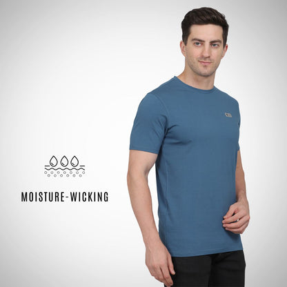 Man wearing a blue t-shirt with moisture-wicking text and logo on a white background